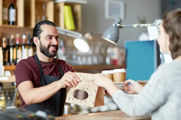 Man passing retail paper coffee bag with window